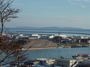 宮城県石巻市日和山より旧北上川河口を望む。川の脇にはガレキの山が出来ている。