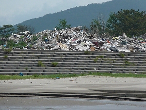 海岸の堤防に山積みされた大量のガレキ。