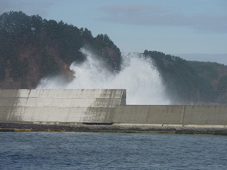 海は大荒れ。防波堤を超える波シブキ。